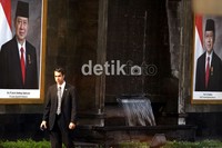 Secret Service dari Amerika Serikat, berjaga di depan billboard Presiden RI Susilo Bambang Yudhoyono dan Wakil Presiden Republik Indonesia Boediono, yang berada di kompleks Bandara Halim Perdakusumah, Jakarta.