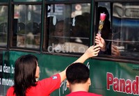 Seorang penumpang bus menerima setangkai bunga.