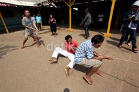 Seorang peserta terjatuh saat mengikuti lomba tarik tambang.