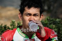 Pembalap motor PON DKI Jakarta M. Dwi Satria, menenggak minuman usai latihan di Sirkuit JI Expo Kemayoran, Jakarta.