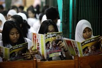 Beberapa siswa membaca selebaran yang berisikan visi dan misi calon gubernur DKI Jakarta.