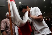 Salah satu pembalap PON DKI Jakarta, melakukan prosesi cium bendera Merah Putih, saat acara pelepasan kontingen PON XVII cabang olahraga Balap Motor DKI Jakarta, di Jakarta.