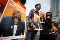 Dalam aksi tersebut salah seorang pendemo mengenakan kostum orangutan.
