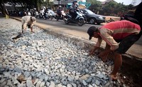 Sejumlah pekerja sibuk menyelesaikan proyek pelebaran Jalan Raya Joglo.