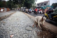Seorang pekerja meratakan material sebelum pengecoran.