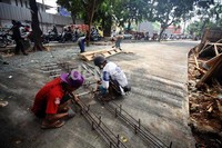Sejumlah pekerja membuat rangka besi yang berfungsi memperkuat kontruksi beton jalan.