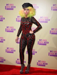 Nicki Minaj memang selalu berusaha tampil beda di setiap kesempatan. Kali ini ia menjadi sorotan publik dengan rambut kuning-pink-kehijauannya itu. Frederick M. Brown/Getty Images.