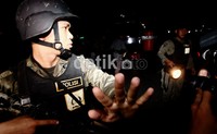 Seorang polisi menghalau warga yang terus berdatangan ke lokasi ledakan. Hasan Alhabshy/detikfoto