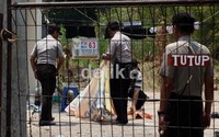 Petugas juga menurunkan dan membawa spanduk yang sebelumnya terpampang di depan rumah tersebut.