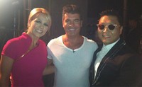 Lewat akun Twitter pribadinya, Britney Spears mengunggah fotonya berpose dengan Simon Cowell dan Psy.