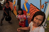 Anak-anak tampak ceria bermain di gang yang berwarna-warni.