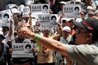 Massa membawa poster bergambar Hartati.