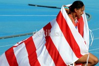 Dedeh Herawati membalut tubuhnya dengan bendera DKI Jakarta seusai menyumbangkan emas di final lari gawang 100 meter putri .