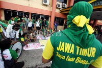 Dalam aksinya selain bernyanyi dan meneriakkan yel-yel, mereka juga membawa poster bertuliskan kritikan terhadap PB PON Riau.