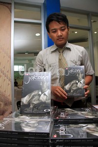Seorang pekerja menunjukkan buku Jokowi Spirit Bantaran Kali Anyar.