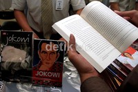 Seorang pengunjung membaca buku Jokowi Spirit Bantaran Kali Anyar.