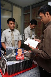 Pengunjung membaca buku Jokowi Spirit Bantaran Kali Anyar.