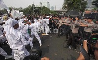 Massa dan polisi sempat bersitegang dengan saling lempar batu sementara polisi melempar gas air mata dan peluru karet.