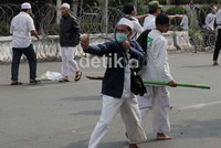 Seorang demonstran tampak telah siap dengan ketapelnya untuk perang dengan polisi.