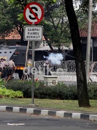 Polisi menembakan gas air mata.