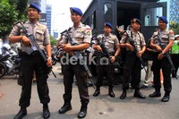 Polisi bersenjata laras panjang berjaga-jaga selama sidang berlangsung.