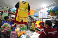 Para pengunjung memilih baju PON yang dijual di Pasar Bawah, Jalan Ahmad Yani, Senapelan, Pekanbaru, Riau.