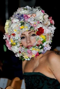 Kepala Lady Gaga ditutupi oleh bunga-bunga yang berwarna-warni. (Gareth Cattermole/Getty Images).