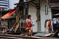 Warga selesai mandi di pinggir rel.