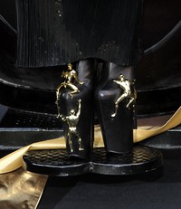 Sepatu dari United Nude itu tampak sangat unik dengan miniatur-miniatur manusia emas yang menempel pada heels tersebut. Rob Kim/Getty Images.