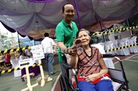 Salah seorang penyandang disabilitas menunjukkan jari kelingking yang telah dicelupkan ke tinta.