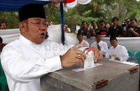 Nara memasukkan surat suara ke kotak suara.