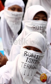 Para peserta aksi mengenakan busana muslim.