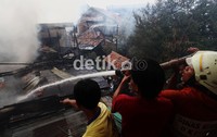 Warga turut membantu petugas pemadam kebakaran memadamkan api.
