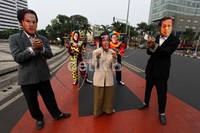 Tiga orang peserta aksi yang memakai topeng Agus Martowardojo, Budiono dan Sri Mulyani melakukan aksi teatrikal.