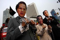 Tiga peserta aksi yang memakai topeng Agus Martowardojo, Budiono dan Sri Mulyani tampak dirantai.