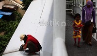 Warga melintas di jembatan yang sedang diperbaiki.