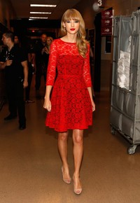 Ia tampak cantik seperti boneka dengan dress merahnya. Isaac Brekken/Getty Images for Clear Channel.