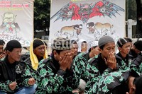 Demonstran khusyuk berdoa di antara poster-poster anti AS yang mereka bawa.