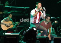 Tim muncul dari belakang kursi penonton kemudian berlari menuju atas panggung. Ia terlihat sempurna dengan setelan kemeja putih.