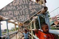 Anak-anak bermain ayunan yang diikat bambu di gang Kawasan Cideng, Jakarta Pusat, Minggu, Sabtu (30/9).