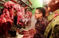 Mengenakan kemeja batik biru, Muhaimin berkeliling pasar.