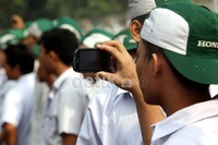 Seorang buruh mengabadikan jalannya aksi.