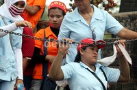 Buruh yang masih mengenakan seragam pabrik turun dari truk.