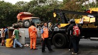 Krat-krat yang digunakan untuk membawa botol bir berserakan di jalan tol. Untungnya krat-krat berwarna kuning itu masih kosong.