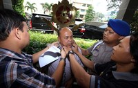 Sejumlah pengunjung dan polisi berusaha melepaskan rantai yang membelenggu Arifin.  (Romy)