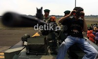 Mereka menaiki tank yang dipamerkan.