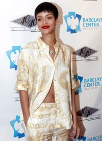 Rihanna tampil dengan make-up natural yang disentuh dengan bibir merahnya. Allison Joyce/Getty Images.