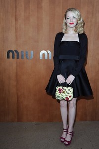 Emma tampak cantik dengan dibalut dress strapless dari Miu Miu dan cardigan hitam yang disentuh dengan sepatu peeptoe pink. Pascal Le Segretain/Getty Images.