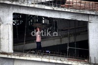 Sejumlah pekerja merampungkan pembangunan perkantoran di kawasan Mega Kuningan, Jakarta. Asosiasi Kontraktor Indonesia mencatat realisasi belanja konstruksi nasional diperkirakan telah melebihi Rp 100 triliun hingga kuartal III 2012.