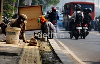 Pekerja memasang rambu tunanetra pada jalur pedestarian di Kawasan Thamrin, Jakarta.